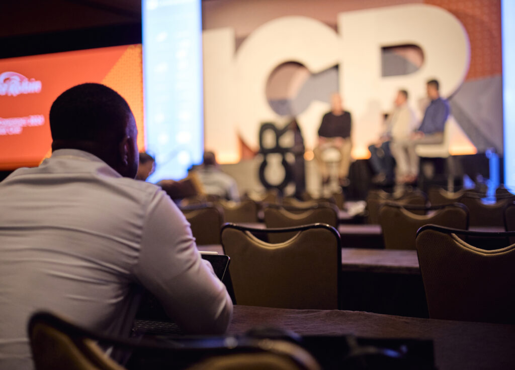 person in the crown listening to speakers on stage at the ICR conference